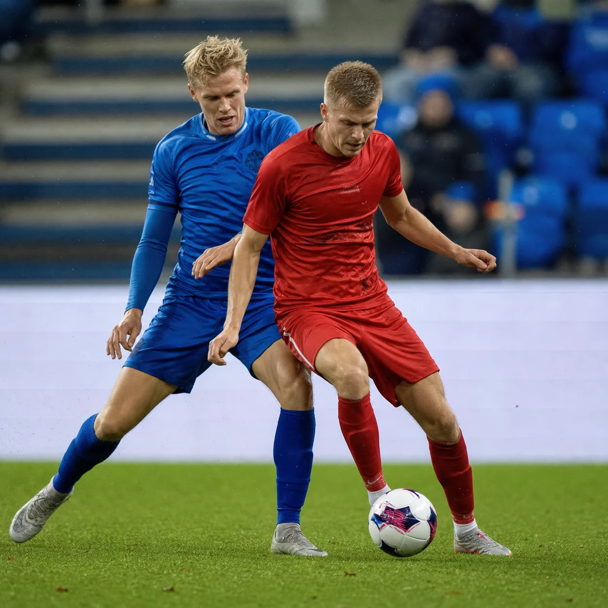 Två fotbollsspelare i närkamp om bollen.