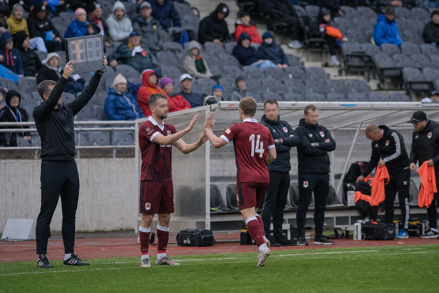 Spelarbyte vid fjärdedomarens skylt med bänken i bakgrunden.