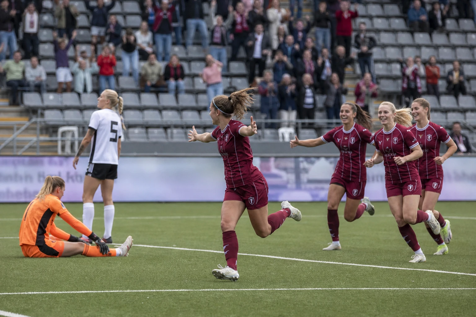 Målskytten vänder bort i jubel med lagkamrater på väg fram.